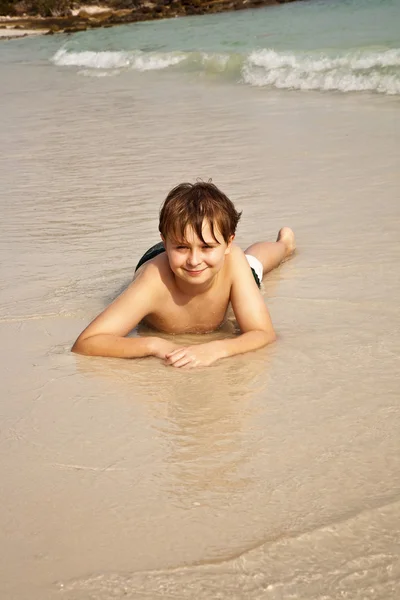 Ragazzo felice sdraiato sulla spiaggia — Foto Stock