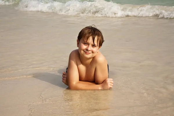 Щасливий хлопчик лежить на пляжі — стокове фото