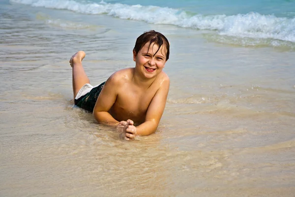 Boldog, fiatal fiú élvezi a strandon — Stock Fotó