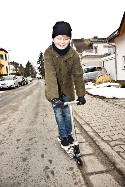 Jeune garçon chevauchant son scooter avec plaisir — Photo