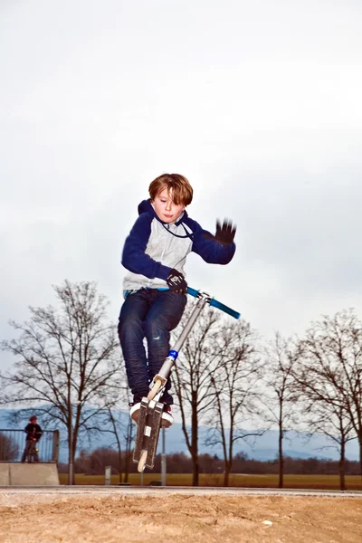 Junge reitet seinen Roller mit Spaß — Stockfoto