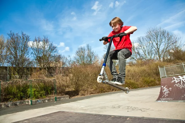 Boy going airborne with a scooter — Stock Photo, Image