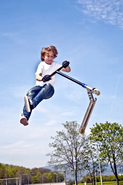 Chłopiec będzie w powietrzu ze skuterem — Zdjęcie stockowe