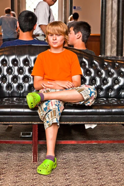 Pojke tar en vila på en soffa — Stockfoto