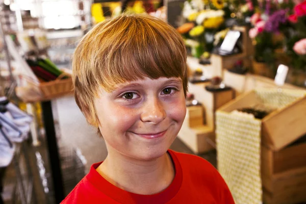 Young boy smiles in a shop — Stock Photo, Image