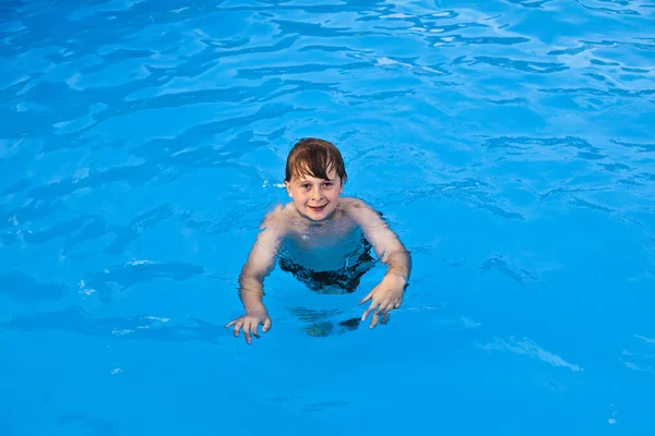 Pojken har kul simmar i poolen — Stockfoto