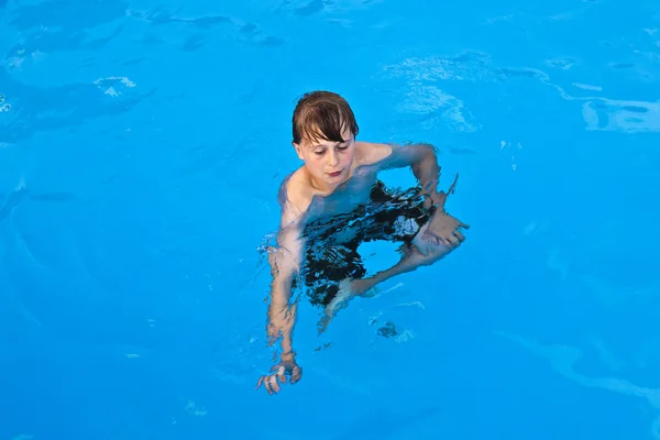 Garçon a plaisir à nager dans la piscine — Photo