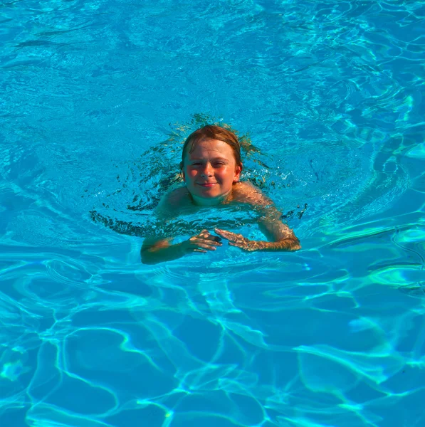 Niño nada en la piscina y se divierte —  Fotos de Stock