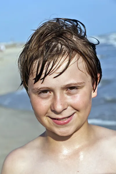 Szczęśliwy chłopiec z mokrych włosów na plaży — Zdjęcie stockowe