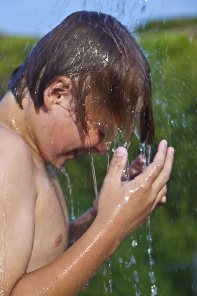 Fiú van egy zuhanyzó, a strandon — Stock Fotó