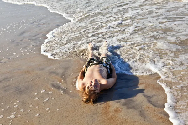 Garçon couché sur la plage et profitant de l'océan — Photo
