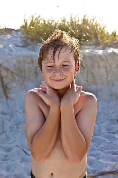 Молодой счастливый улыбчивый мальчик на пляже — стоковое фото