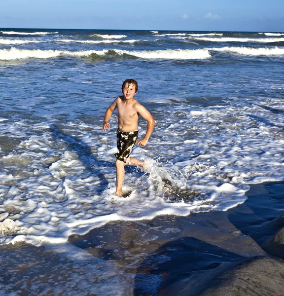 Joven niño disfruta de las olas del mar azul —  Fotos de Stock