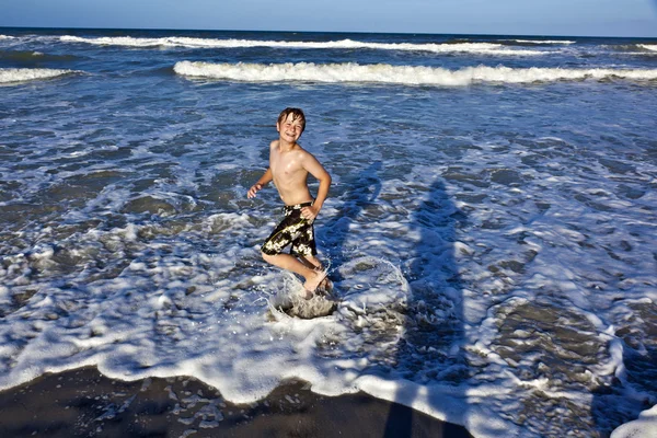 Fiatal fiú élvezi a kék tenger hullámai — Stock Fotó