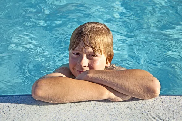 Bambino riposare sul gomito sul bordo della piscina — Foto Stock