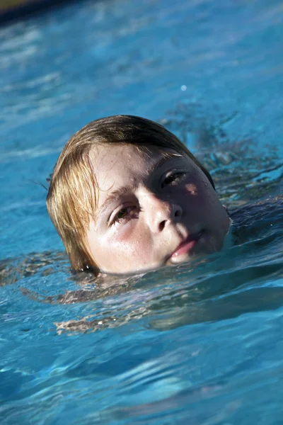 Boldog gyermek úszás a medencében — Stock Fotó