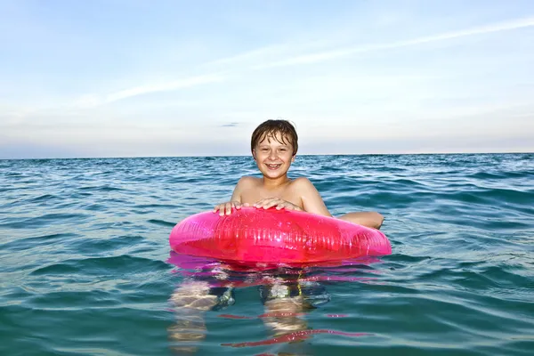 Chico en un anillo de natación se divierte en la ocea —  Fotos de Stock