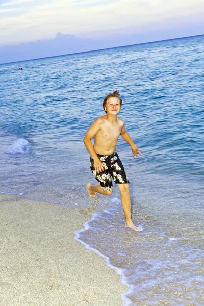 少年は美しいビーチでジョギングします。 — ストック写真