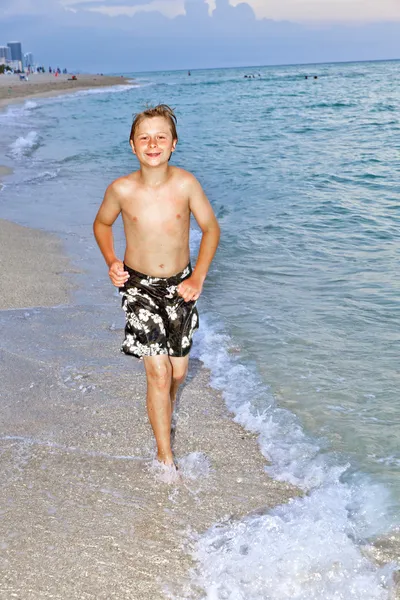 Menino está correndo na bela praia — Fotografia de Stock