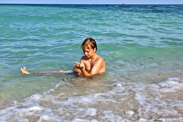 Мальчик наслаждается чистой водой в океане — стоковое фото