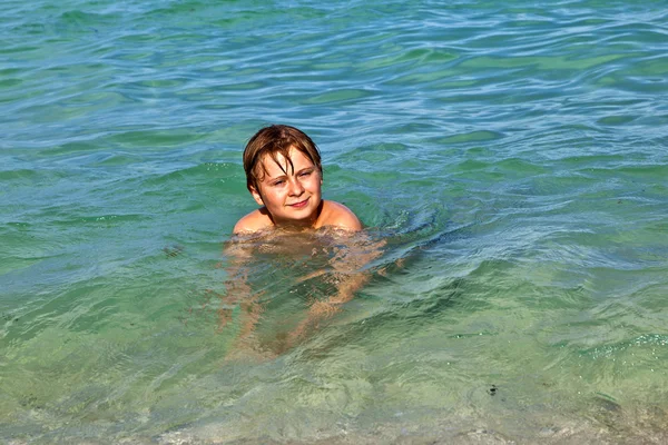 Boy enjoys the clear water in the ocean — Stock Photo, Image