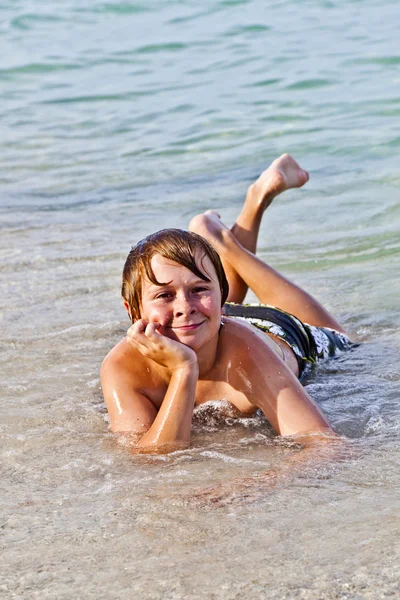 Хлопчик любить лежати на пляжі в серці — стокове фото