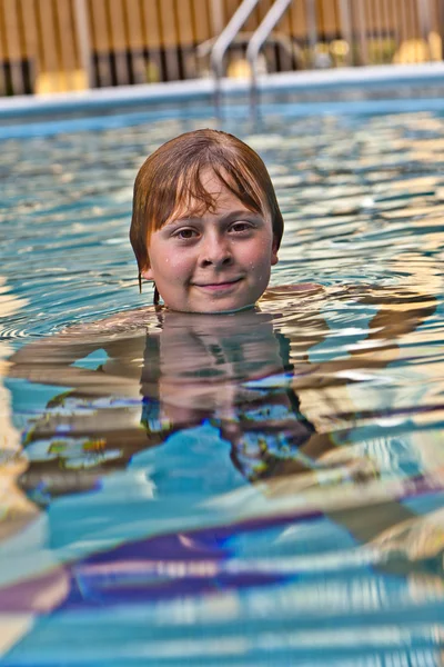 Αγόρι απολαμβάνει το κολύμπι στην εξωτερική πισίνα — Φωτογραφία Αρχείου