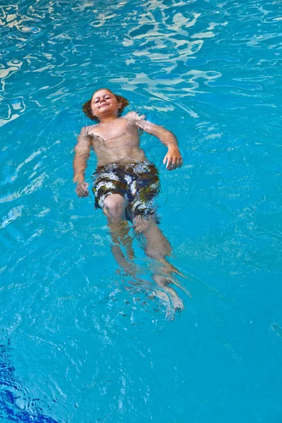Мальчику нравится плавать в открытом бассейне — стоковое фото