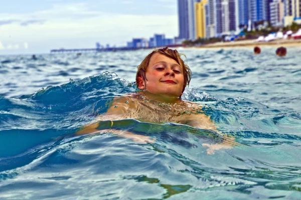 Jongen is zwemmen in de Oceaan — Stockfoto