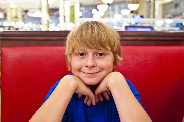 Niño sonriente en una cafetería por la noche — Foto de Stock