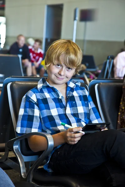 少年は空港の出発を待っています。 — ストック写真