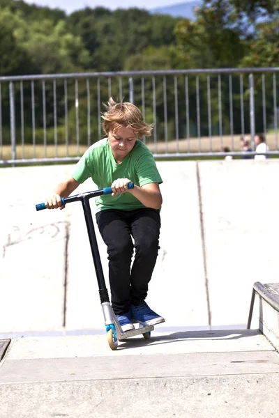 Jeune garçon va dans les airs avec son scooter — Photo
