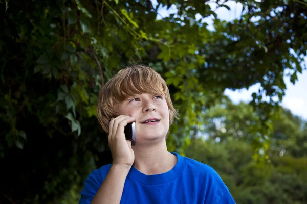 Mladý chlapec mluví do mobilu. — Stock fotografie