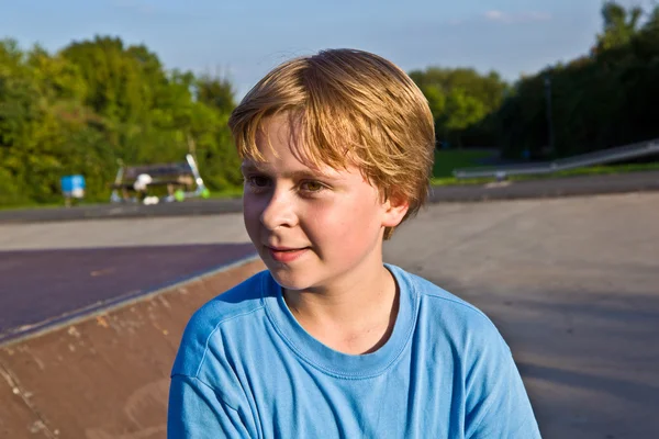Niño salta con scooter en el parque de skate sobre una rampa — Foto de Stock