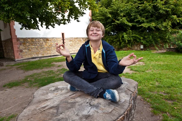 Young boy smiles and has fun by meditating — Stock Photo, Image