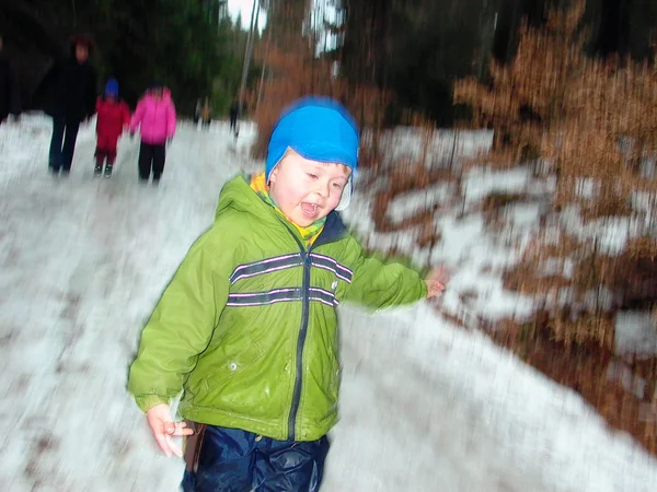 Los trineos del niño abajo de la colina nevada —  Fotos de Stock