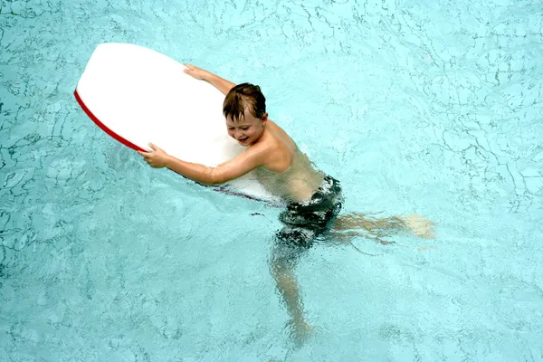 Menino na prancha de surf na piscina — Fotografia de Stock
