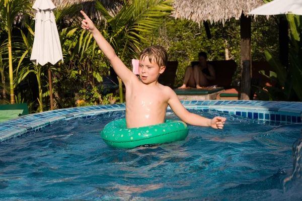 Giovane ragazzo in un pneumatico floting gode di acqua dolce in piscina — Foto Stock