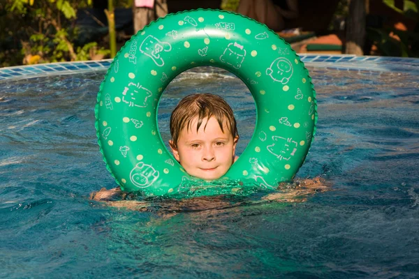 Junge schwimmt mit Ring im Pool — Stockfoto