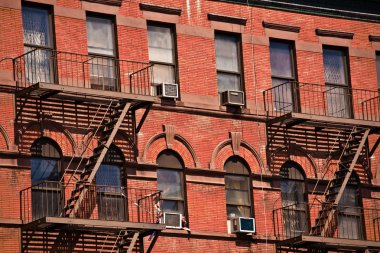 Fire ladder at old houses downtown in New York clipart