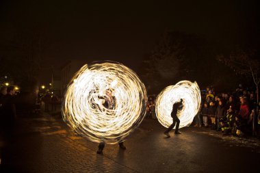 Young perform a fire spectacle at night for the audience of the Chri clipart