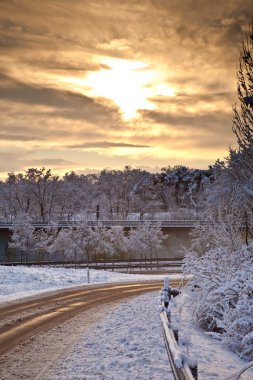 Snow covered street in sunrise in winter clipart