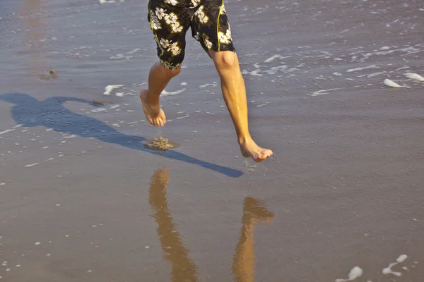 Voeten van jongen loopt langs het strand — Stockfoto