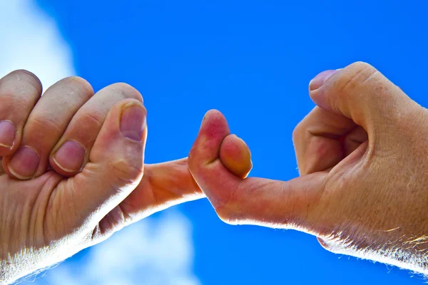Två fingrar med blå himmel — Stockfoto