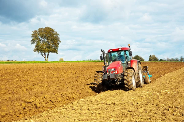 Traktor med plog på fältet — Stockfoto