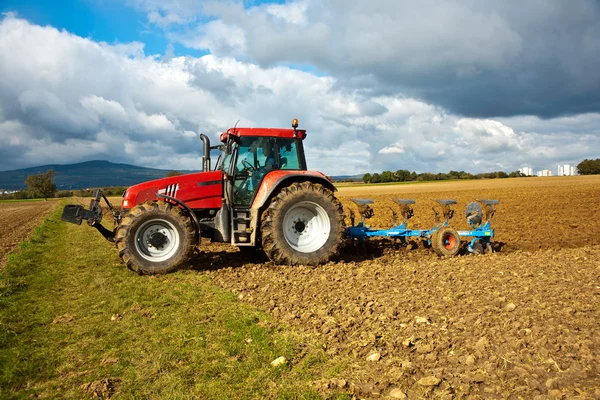 Traktor mit Pflug auf Feld — Stockfoto