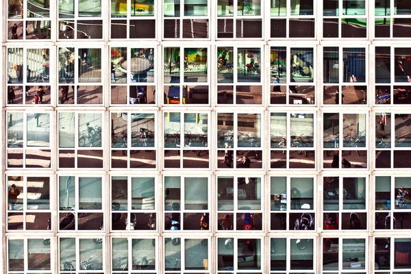 Отражение уличной жизни в офисном здании — стоковое фото