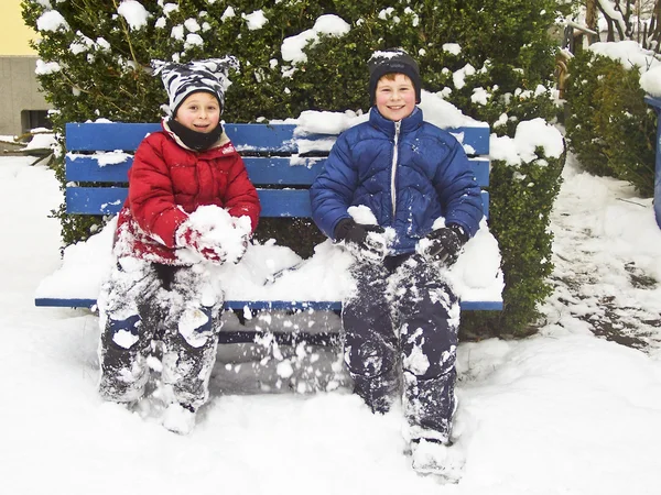 Hermanos sentados en invierno en un banco — Foto de Stock