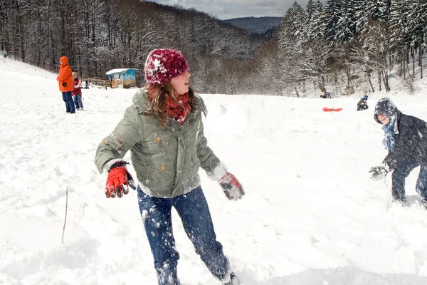 Dívka a chlapec se baví s sněhová koule bitevní — Stock fotografie