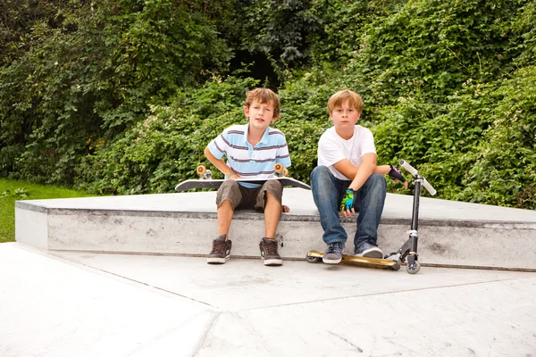 Os rapazes estão sentados numa caixa no parque de skate. — Fotografia de Stock